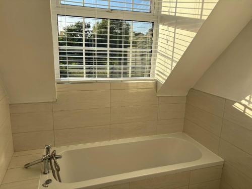 a white bath tub in a bathroom with a window at Mountingrovebnb in Piltown