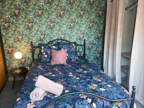 a bedroom with a bed with a flowery wallpaper at Suite l Instant suspendu maison 25m2 avec coin salon Wifi Netflix Maison Like and Love Duclair in Duclair