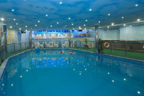ein großer Pool mit blauer Beleuchtung in einem Gebäude in der Unterkunft Royal Casablanca in Dschidda