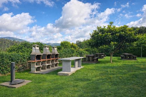 a park with benches and a table in the grass at Nova MSuites Xove in Lago