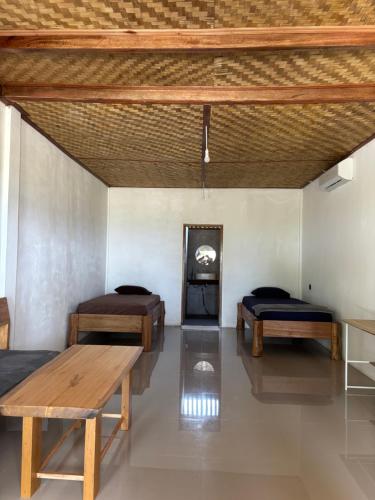 a room with two beds and a table and a fireplace at Onaza Homestay Bintang in Katiet