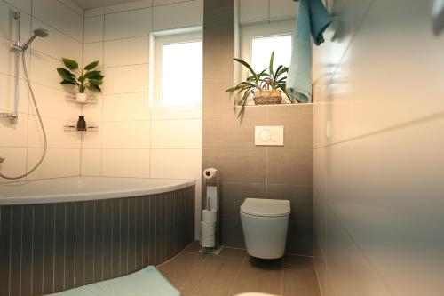 a bathroom with a tub and a toilet and a sink at Wasser & Bergwelt Appartement Kärnten in Seeboden