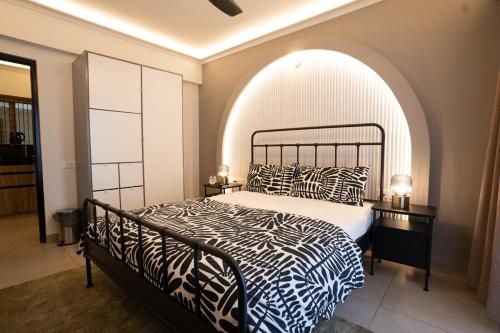a bedroom with a bed with a black and white comforter at Bella casa in Siolim