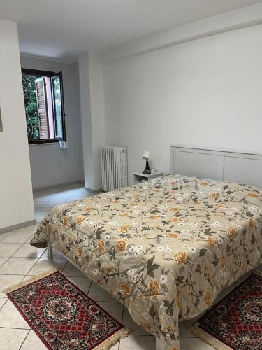 a bedroom with a bed with a floral bedspread on it at Casa Maggini in Ancona