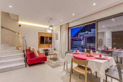 a living room with a table and a red chair at Angels Suites in Plataniás