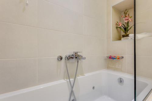 a white bath tub with a shower in a bathroom at Angels Suites in Plataniás