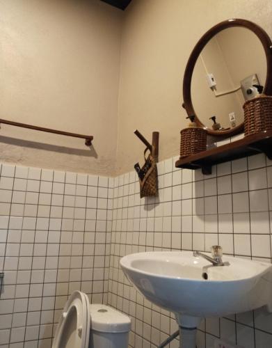 a bathroom with a sink and a mirror and a toilet at Vinla Guesthouse & Backpackers Hostel in Nongkhiaw