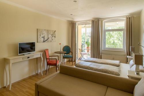 ein Wohnzimmer mit einem Sofa und einem TV in der Unterkunft Wohlfühlen mit großem Balkon in Erfurt