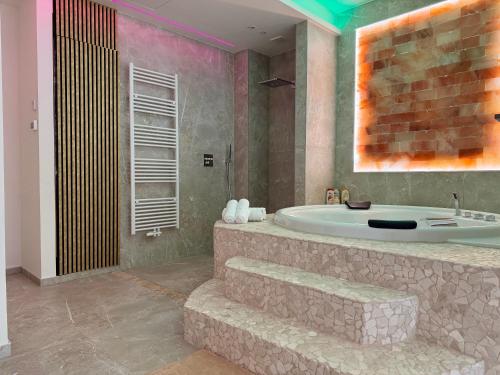 a bathroom with a bath tub and a sink at Salt Spa de Panne center in De Panne