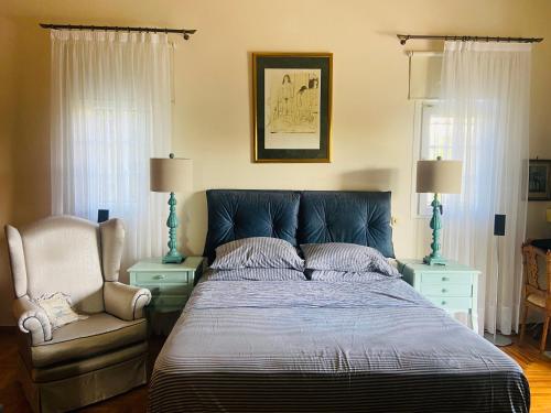 a bedroom with a large bed and a chair at Villa Eleni in Lagonissi