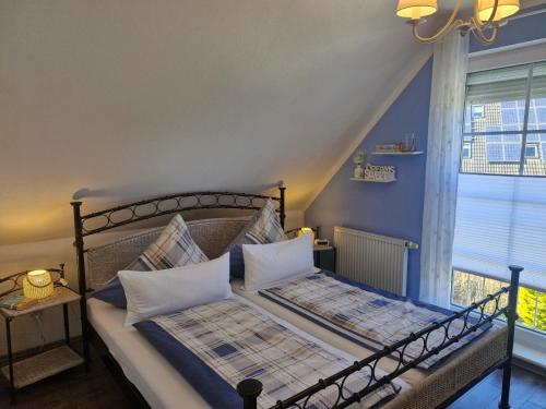 a bedroom with a bed with blue walls and a window at Lilly & Fine in Zingst
