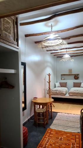 a room with a bed and a table and a room with a bed at Ryad Fnina in Tiznit