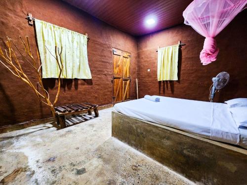 a bedroom with a bed in a room with windows at Clay Hut by Ever Green Eco Resort in Wilpattu