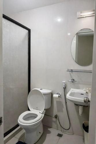 a white bathroom with a toilet and a sink at Zolaria Hotel and Restaurant in Tagaytay