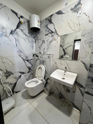 a bathroom with a white toilet and a sink at Hotel Jaya shree in Ujjain