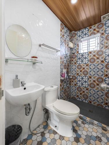 a bathroom with a white toilet and a sink at Bella Casa (3BR House at Azienda Genova) in Talisay