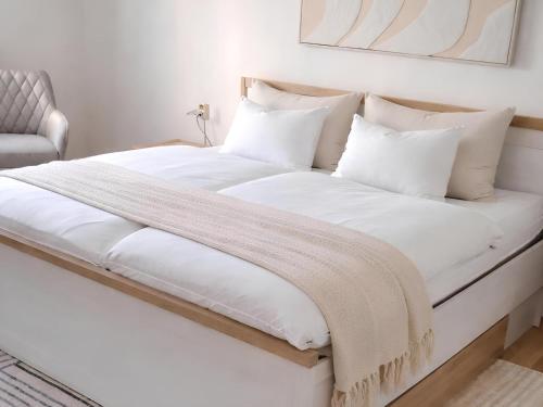 a large bed with white sheets and pillows at Komfortable Ferienwohnung 2x Schlafzimmer, Sauna zubuchbar, Parkplatz & Top Lage in Bad Muskau in Bad Muskau