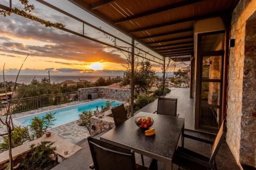 a view from the balcony of a house with a table with fruit on it at Thalassori Villas in Agios Nikolaos