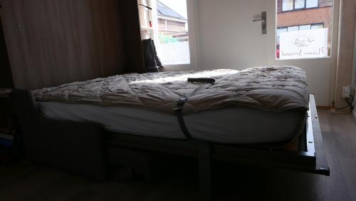 a large bed in a room with a window at Nieuw Strand in Petten