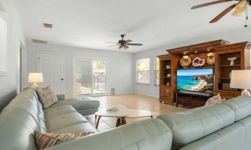 a living room with a couch and a flat screen tv at Spacious 5BR Pool Oasis Near Disney Resort in Sebastian