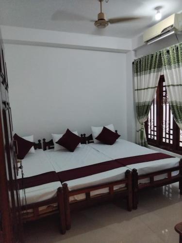 a bedroom with a bed with black and white pillows at Blue Moon Rest Inn in Trincomalee