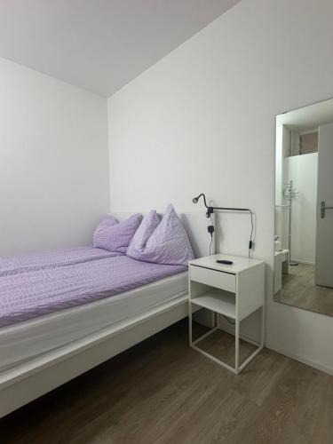 a white bedroom with a bed and a nightstand and a mirror at Holiday On The Lake Lugano 5 in Bissone