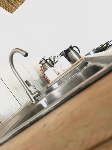 a stainless steel kitchen sink with a faucet at Akagera Able Lodge in Akagera
