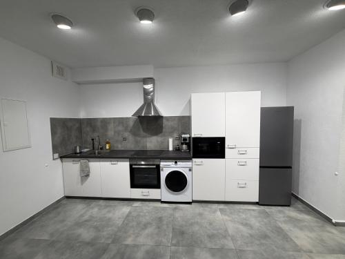 a kitchen with white cabinets and a stove top oven at WiLDBED DE Mitte in Bad Wildbad