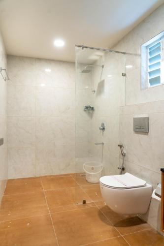 a bathroom with a toilet and a glass shower at Trunk and Trolley, Gachibowli, A Luxury Boutique Hotel, Hyderabad in Hyderabad