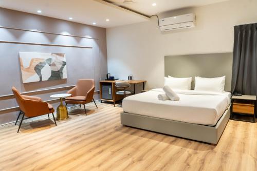 a bedroom with a bed and a desk and chairs at Trunk and Trolley, Gachibowli, A Luxury Boutique Hotel, Hyderabad in Hyderabad