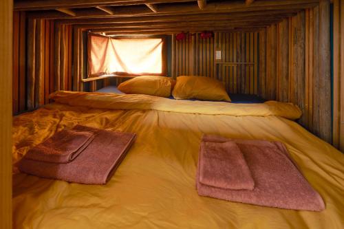 a bed in a room with two towels on it at Glampervan Rietje in Den Bosch