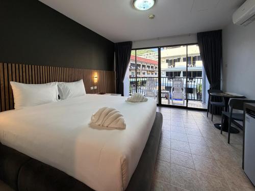 a hotel room with a large bed and a balcony at Karon Place in Karon Beach