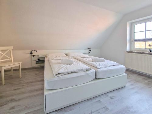 a white bedroom with two beds in it at Strandkrabbe in Greetsiel