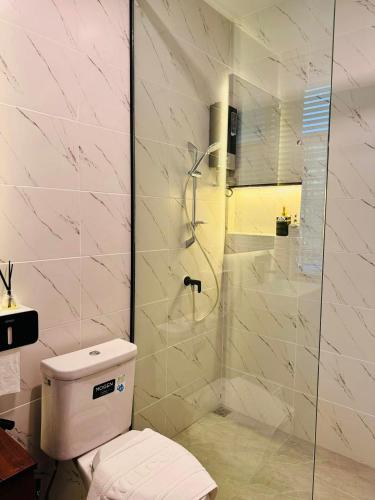 a bathroom with a toilet and a glass shower at Little Bangkoknoi in Ban Bang Si Thong