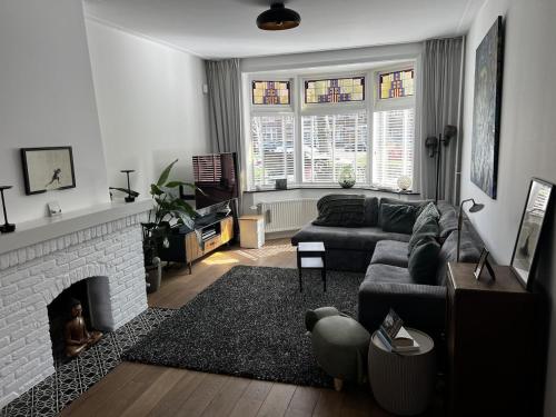 a living room with a couch and a fireplace at Holiday Home in Center Haarlem near Bloemendaal-Zandvoort Beach private garden in Haarlem