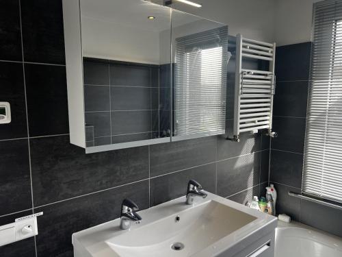 a bathroom with a white sink and a mirror at Holiday Home in Center Haarlem near Bloemendaal-Zandvoort Beach private garden in Haarlem