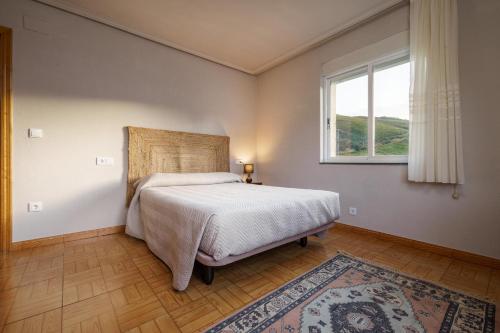 a bedroom with a bed and a window and a rug at Casa Outeiro in Encinedo