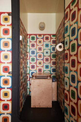 a bathroom with a toilet in a room with colorful walls at Glampervan Julietta in Den Bosch
