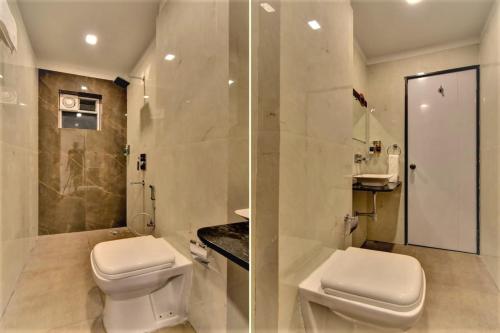 a white bathroom with a toilet and a shower at Hotel Manomay in Nagpur
