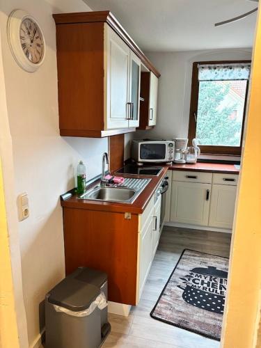 a small kitchen with a sink and a microwave at gemütliche Ferienwohnung in Burgstaedt