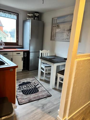 a kitchen with a stainless steel refrigerator and a table at gemütliche Ferienwohnung in Burgstaedt