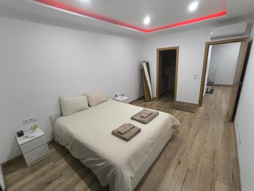 a bedroom with a bed with two towels on it at Residência SB in Odivelas