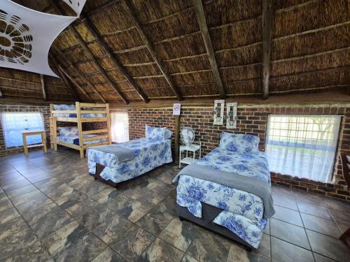 a bedroom with two beds and a brick wall at Midvaal Guesthouse in Meyerton