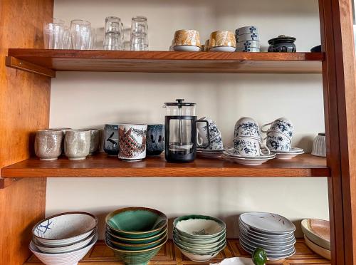 a shelf with plates and cups and a blender at Tani House Tokiwa Nozawa Onsen & More in Iiyama
