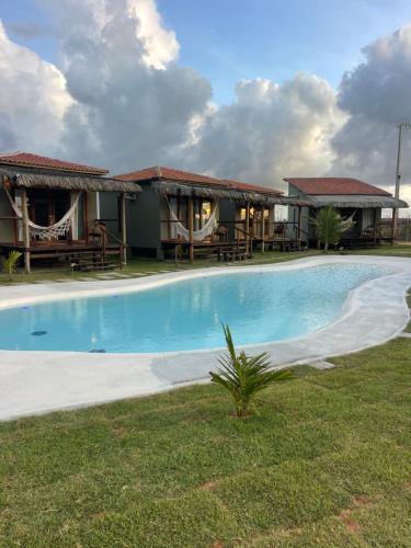 a swimming pool in front of a resort at Amigos do Vento Chalés e Kite Point in Touros
