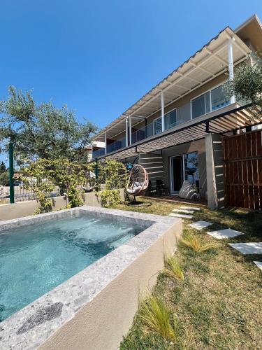 a swimming pool in front of a house at Hotel Amare in Palasë