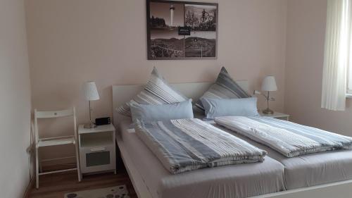 a white bedroom with two beds with pillows at Ferienwohnung Sommerwind in Willingen