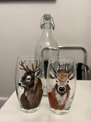 two wine glasses with deer heads on them on a table at The Lili & Orchid Guesthouse in Oban