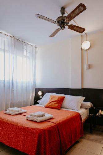 a bedroom with a bed with a ceiling fan at Hotel Temu in Villa Carlos Paz
