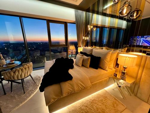a bedroom with a large bed and a table at Sky Suite 22 Hanza Tower in Szczecin